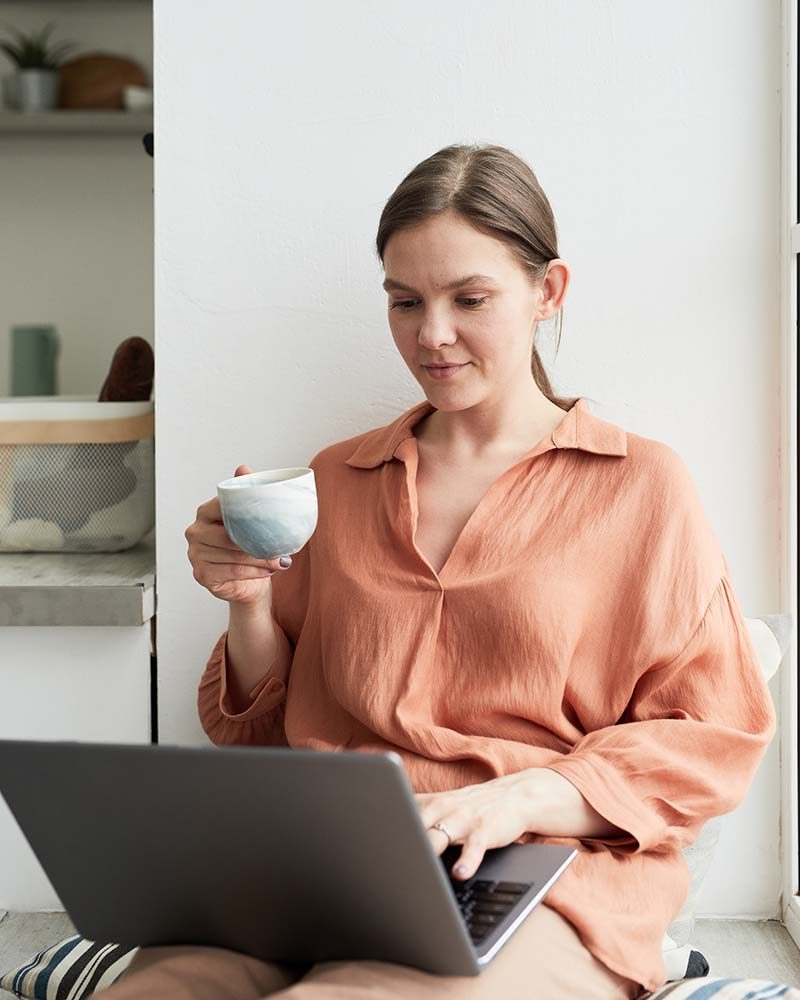woman-working-on-laptop-and-drinking-coffee-LMBVWAA.jpg